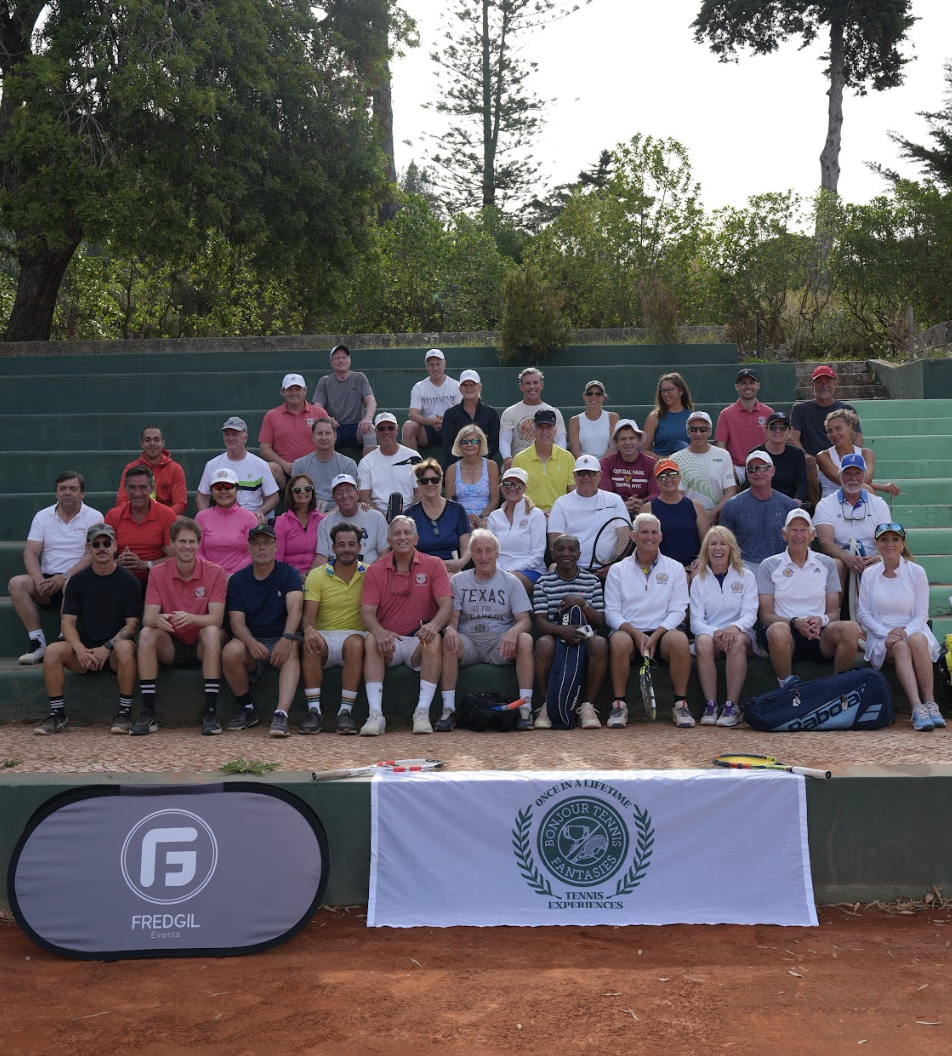 Large group of FREDGIL tennis players and coaches on clay court bleachers