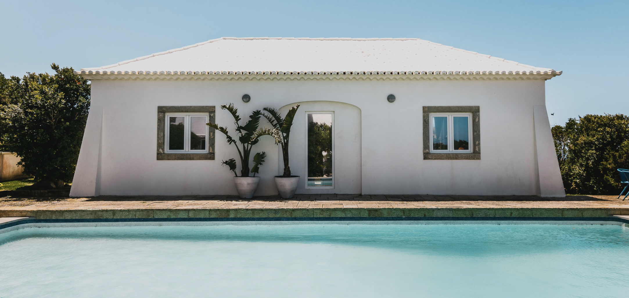 Whitewashed Portuguese villa with traditional tiled roof and turquoise pool
